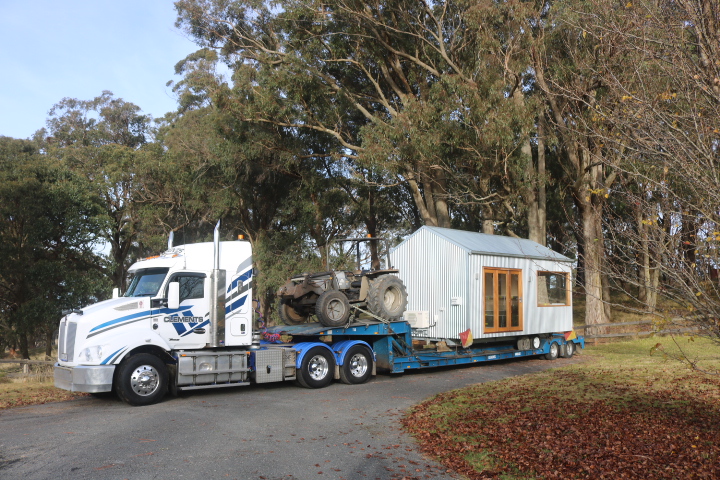 White Zinc Studio cabin transported on a low-loader truck