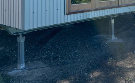 Steel skid supported by adjustable legs fixed to concrete footings