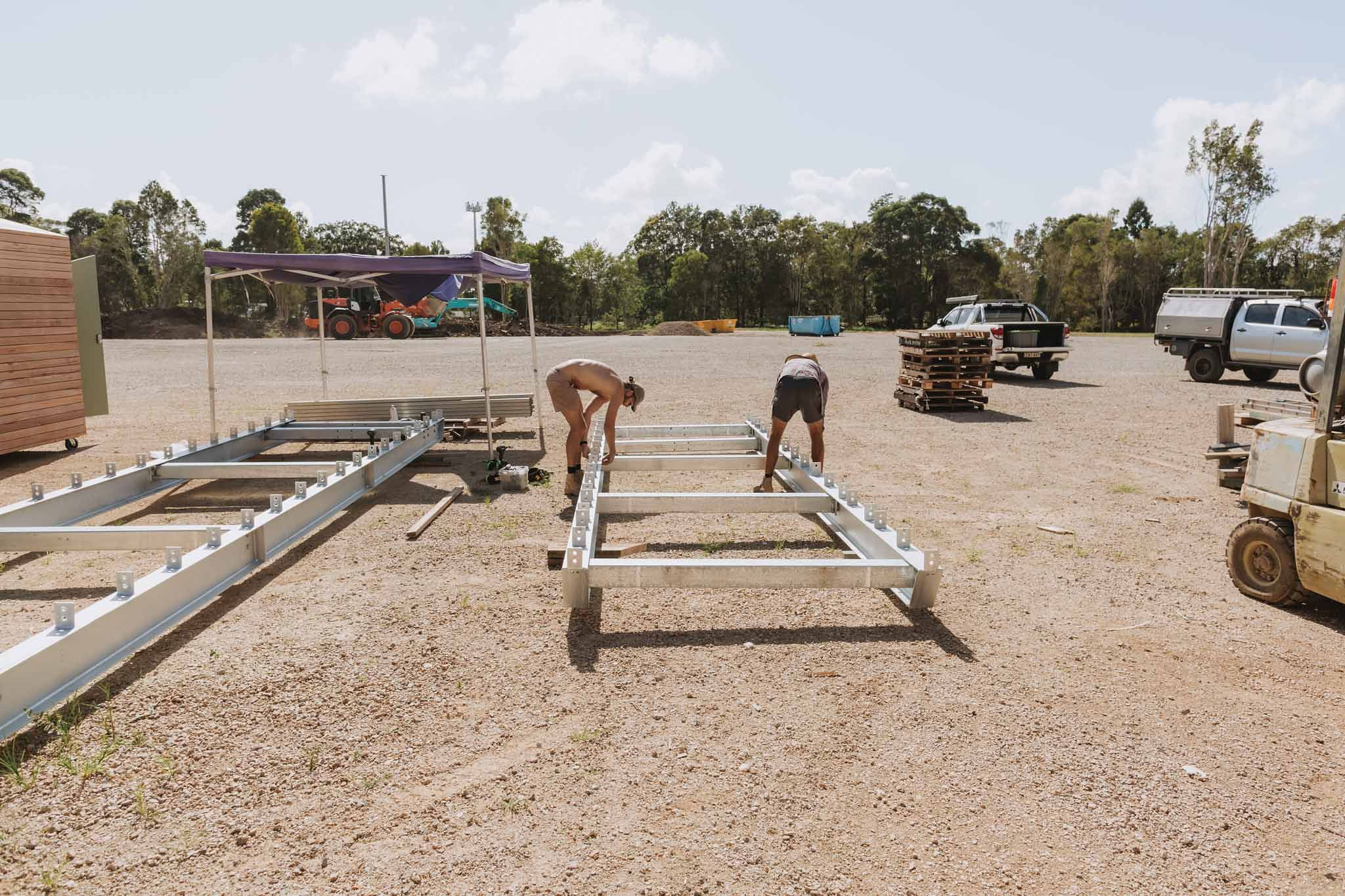 Builders assembling heavy-duty steel bearers and cross beams