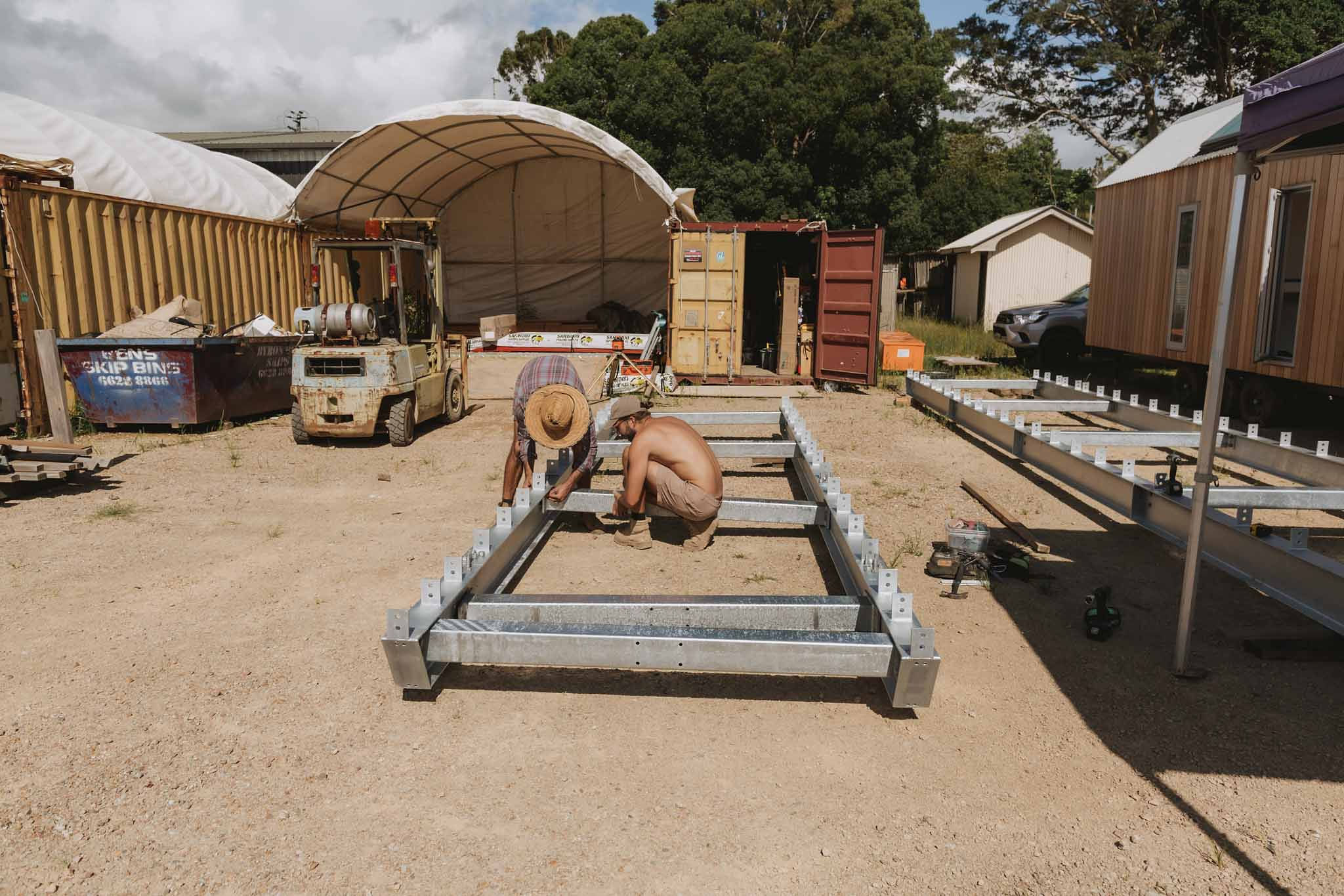 Builder fitting cross beams inside a steel skid frame