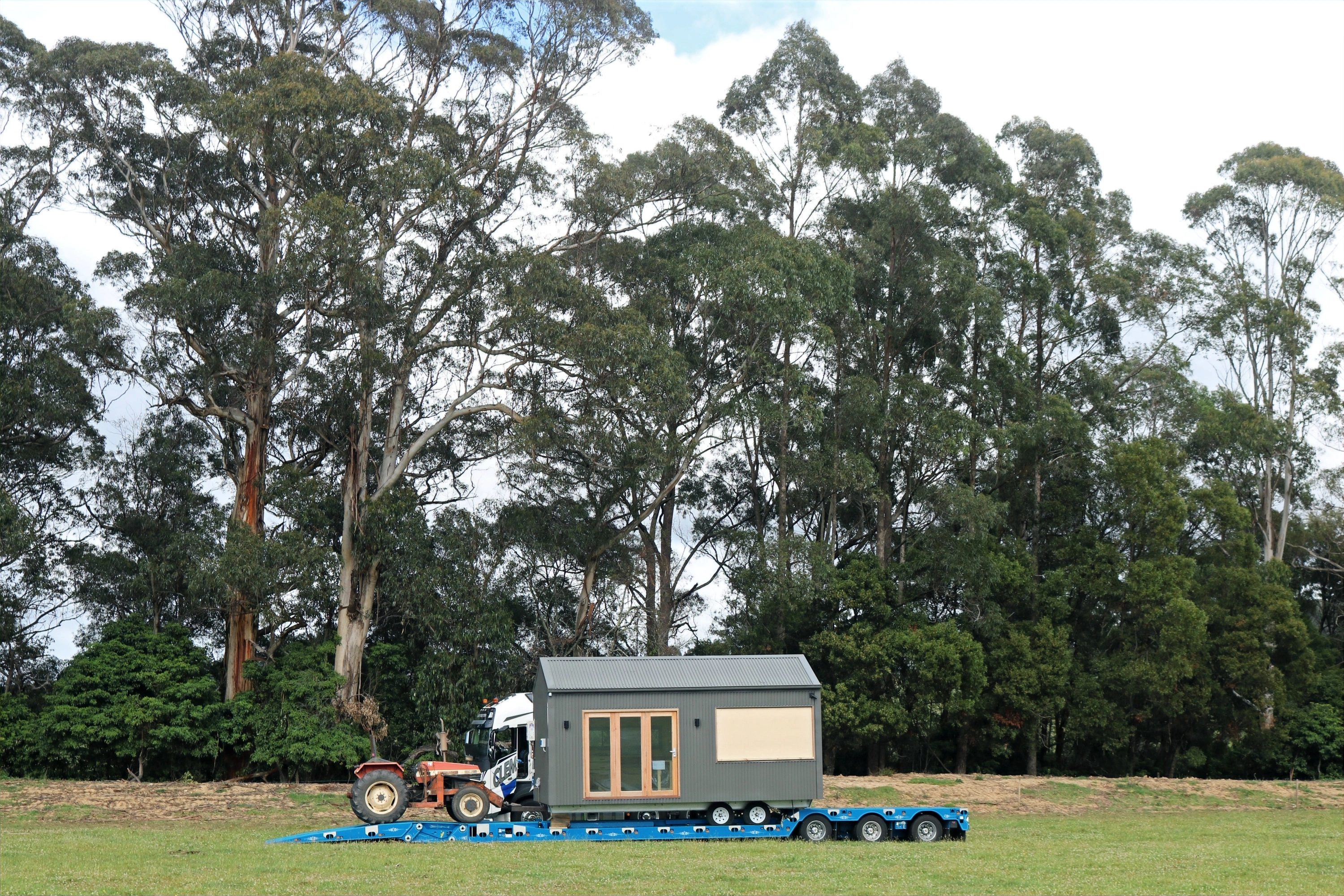 Zinc Studio Cabin being unloaded with on-board tractor.