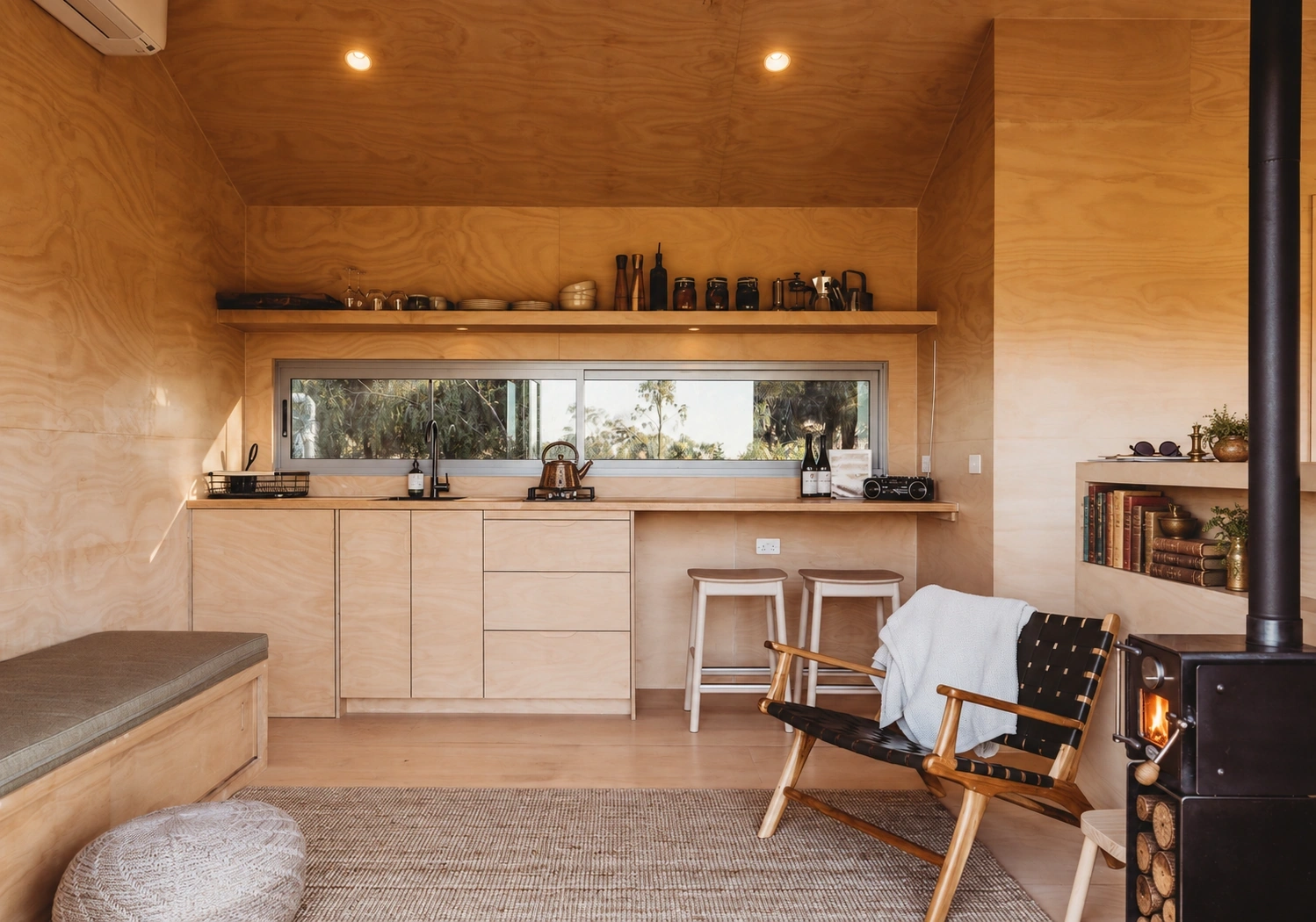 Timber-lined Zinc Studio kitchen and living space with a wood-burning fireplace